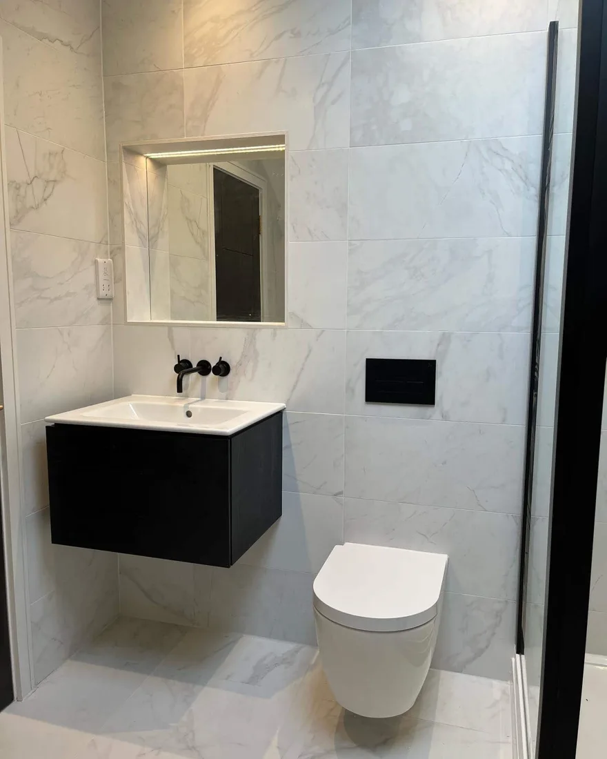 Completed bathroom renovation with marble tiling and freestanding vanity