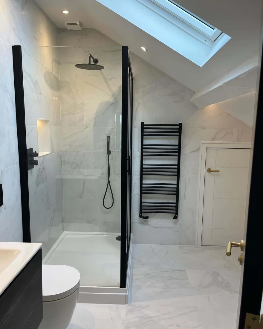 Walk-in shower with marble tiling and black fixtures