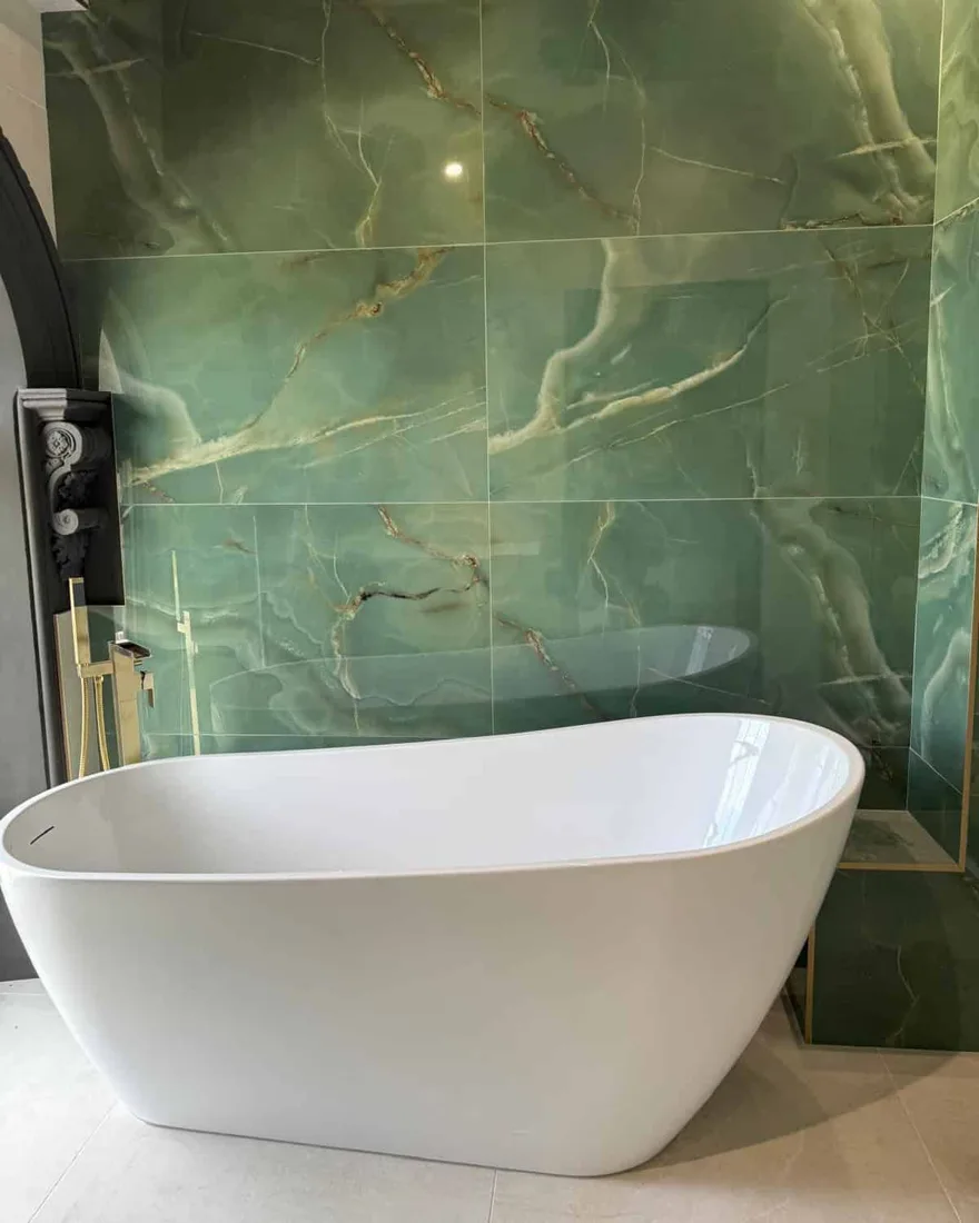 Freestanding bath installation with gold fittings