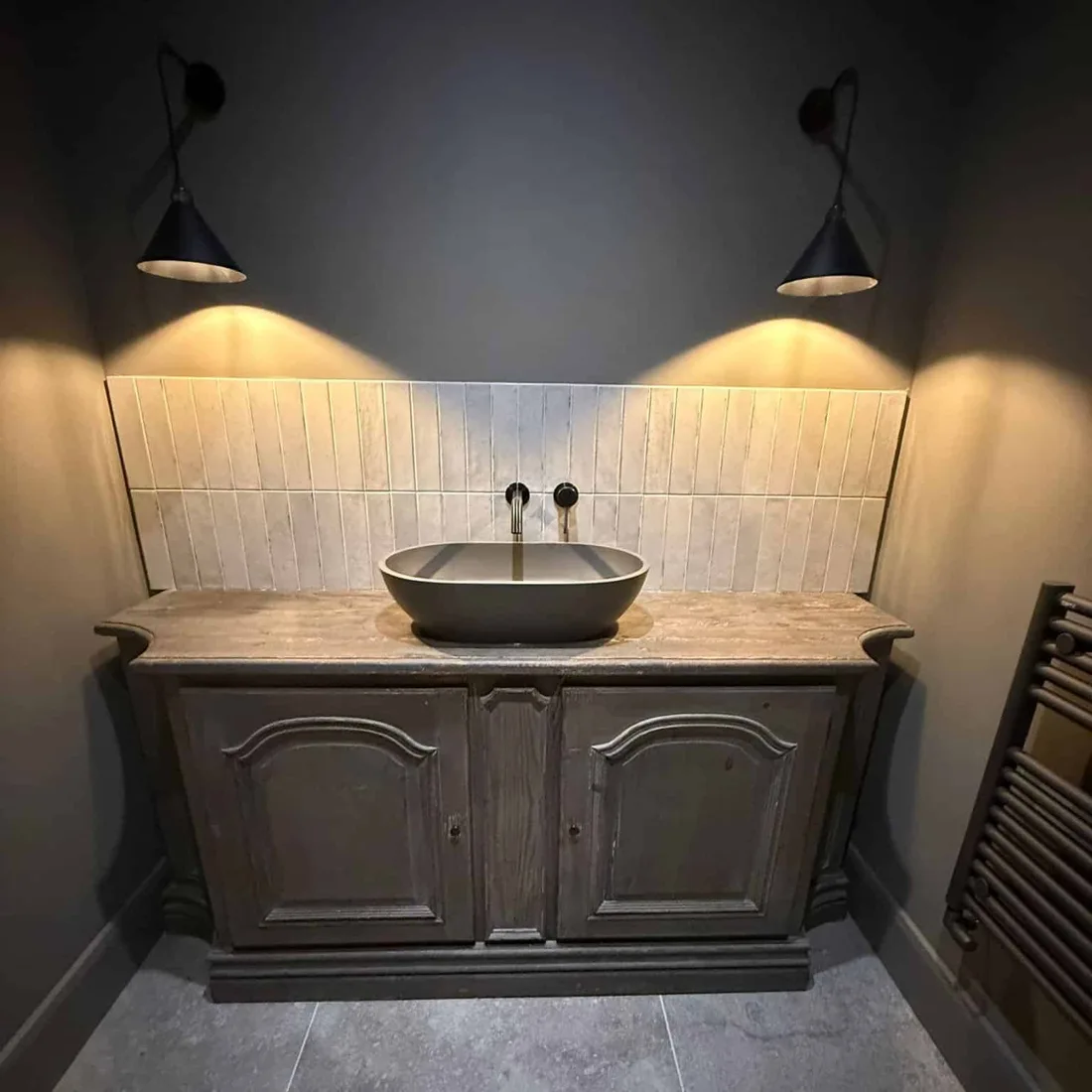 Vessel sink vanity installation with wall-mounted lighting