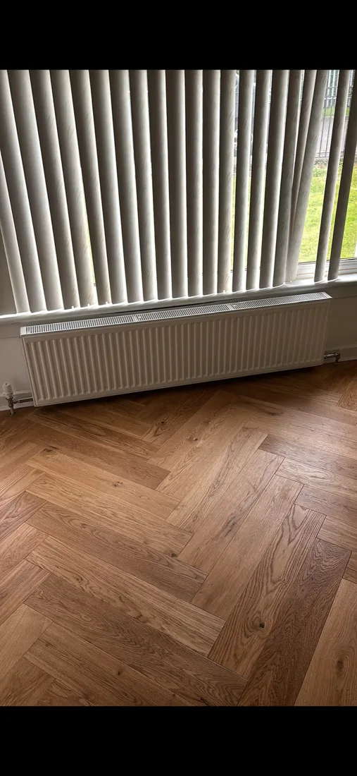 Radiator installed beneath a window in a renovated room